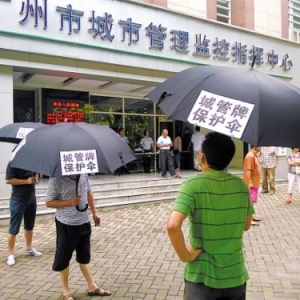 广州市民撑伞上访 称城管是违规建筑保护伞