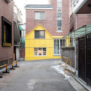 Kaf Nordic Yellow house-shaped facade fronts cafe by Nordic Bros. Design Community